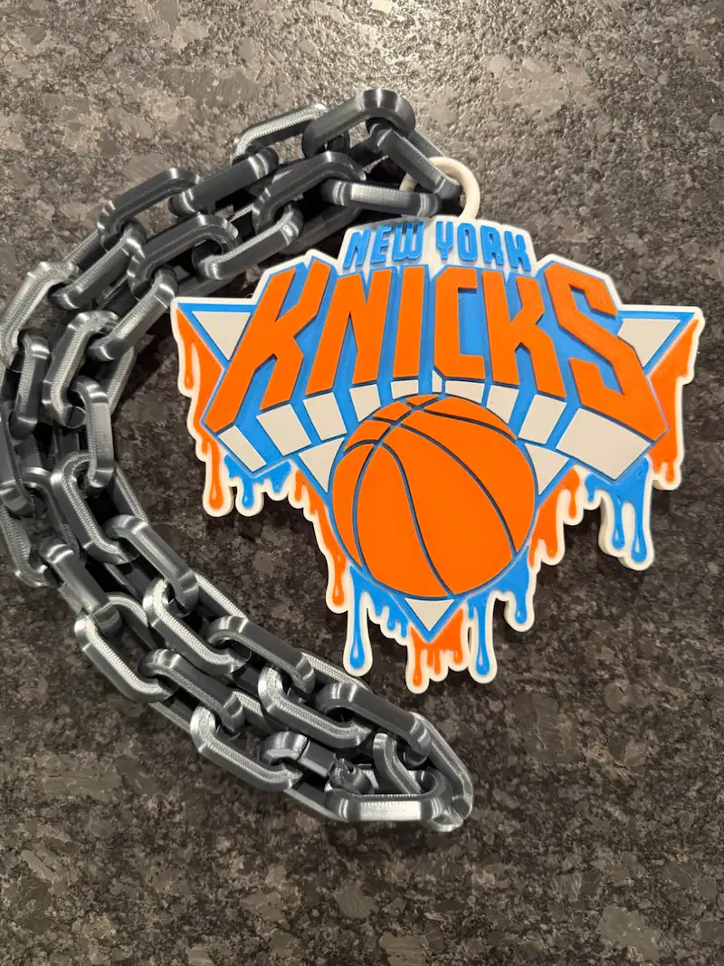 Close up of New York Knicks logo charm attached to custom 3D printed chain
